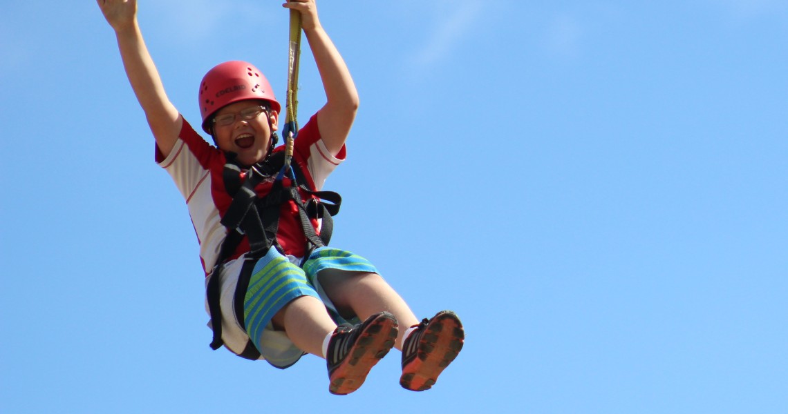 Youth zip-lining during summer activity in Twin Falls, ID.