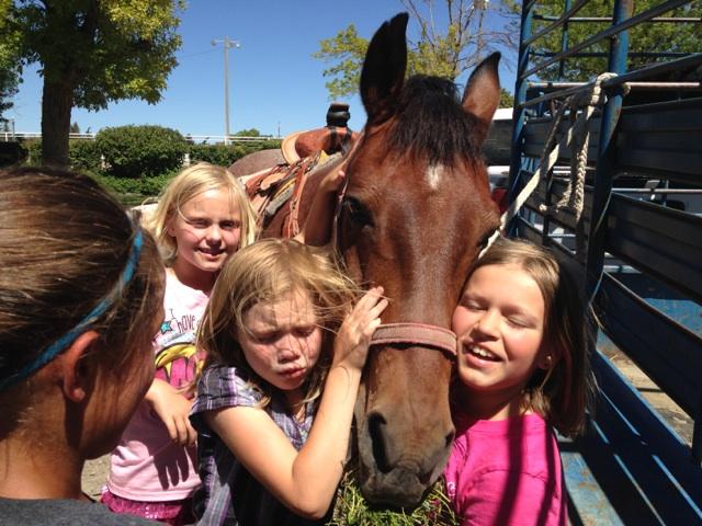 Girls posing with horse during summer campl