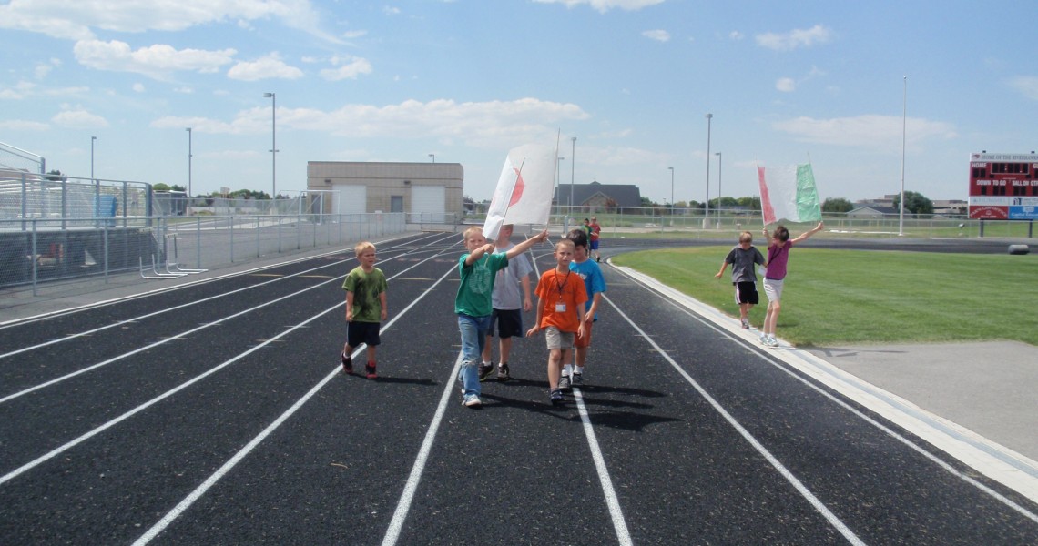 Children on an athletic track during summer activity.