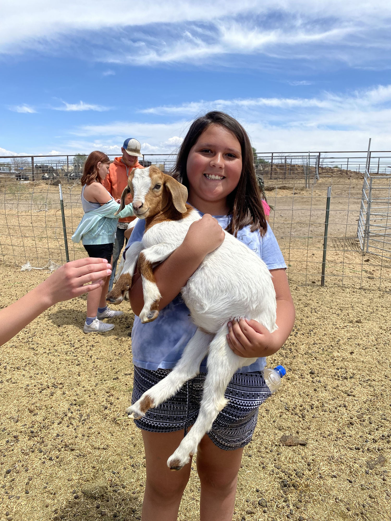 Girl holding goat in summer activity in Rupert, ID.
