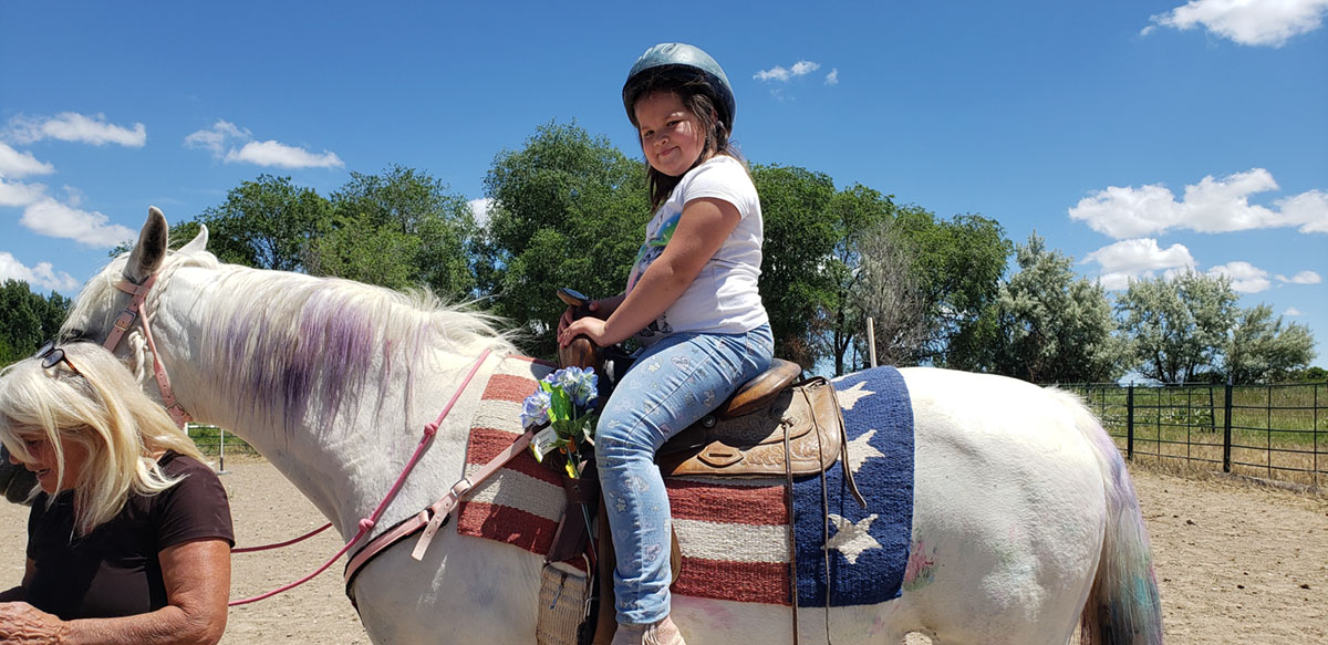 Girl riding horse as a part of summer camp in Twin Falls, ID.